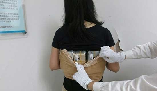 Kadın kaçakçı vücuduna sardığı 102 iPhone ile yakalandı