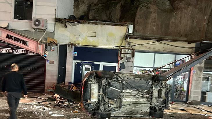 Car falls from 50-metre cliff onto businesses