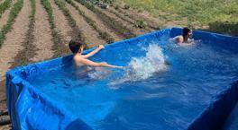 El calor abrumado, convirtió su tractor en la piscina para sus nietos