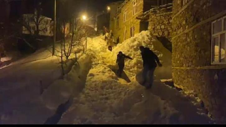 Karla kaplı mahallede hayvanları için gece saman taşıyorlar