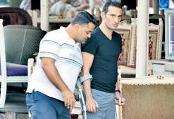 Koltuk değnekleriyle  yürüyor