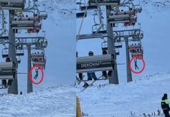 Düşen snowboardını almak için atlamaya çalıştığı telesiyejde asılı kaldı