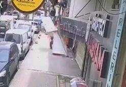 Takmaya çalıştığı tabelayla kaldırımda bekleyen kişinin üzerine düştü