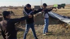 Üç çocuğuna tüfek ve silahla atış talimi yaptırdı