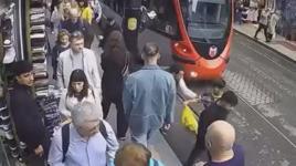 İstanbul'da bir kişinin tramvay yolundaki çocuğu olası kazadan kurtarması kamerada