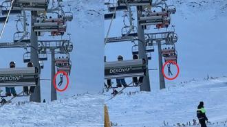 Düşen snowboardını almak için atlamaya çalıştığı telesiyejde asılı kaldı