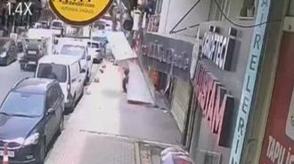 Takmaya çalıştığı tabelayla kaldırımda bekleyen kişinin üzerine düştü