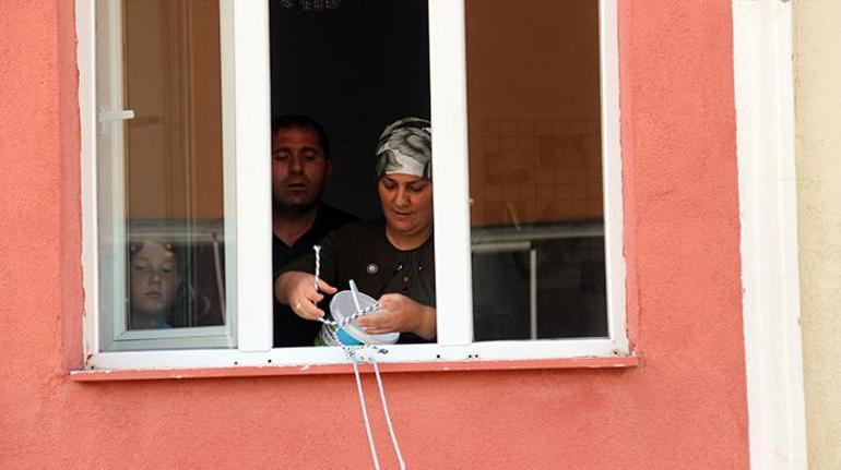 Apartmanda ip ve kova ile oluşturulan makara sistemiyle şeker topladılar