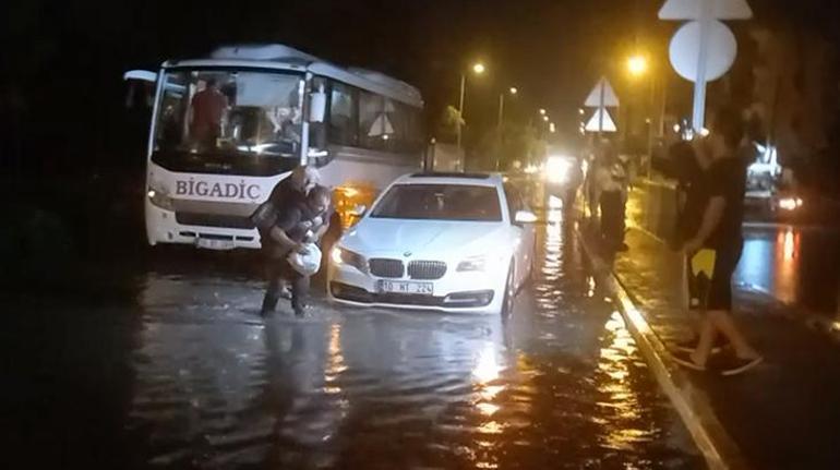 Suyla dolan caddede yaşlı kadını sırtına alıp karşıya geçirdi